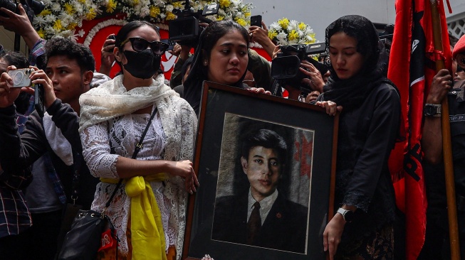 Cucu pertama Presiden ke-5 RI Megawati Soekarnoputri, Diah Lupita Jasmina Srita Putri Arum (tengah) membawa bingkai foto Mohammad Guruh Irianto Soekarnoputra di Jalan Sriwijaya Raya, Kebayoran Baru, Jakarta, Sabtu (26/9/2026). [ANTARA FOTO/Darryl Ramadhan/nz] 