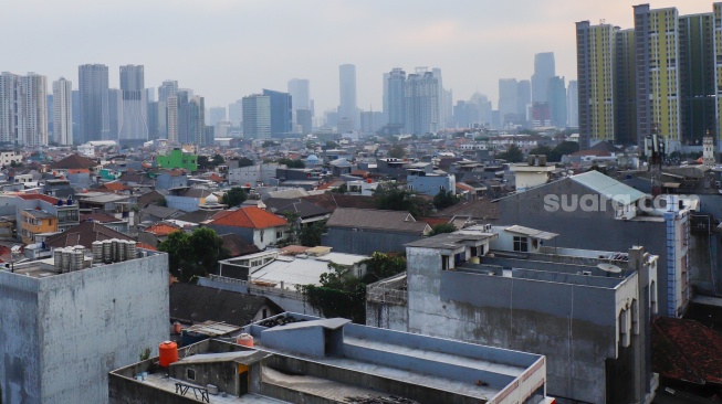 Suasana permukiman padat yang berdampingan dengan gedung-gedung bertingkat di Jakarta, Senin (28/9/2026). [Suara.com/Alfian Winanto]
