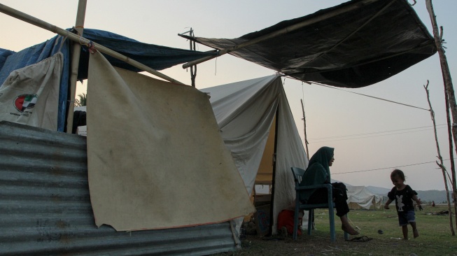 Warga penyintas gempa bumi bercengkerama dengan anaknya di depan tenda pengungsian di Tendakinde, Kabupaten Nagekeo, Nusa Tenggara Timur, Selasa (29/9/2026). [ANTARA FOTO/Mega Tokan/app/rwa]