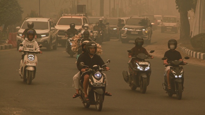 Sejumlah pengendara motor melintasi Bundaran Burung saat kabut asap di Palangka Raya, Kalimantan Tengah, Selasa (29/9/2026). [ANTARA FOTO/Auliya Rahman/rwa]