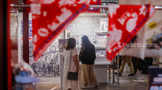 Pengunjung mengamati berbagai karya seni yang ditampilkan dalam Jakarta Illustration and Creative Arts Fair (JICAF) 2026 di Agora Mall, Thamrin, Jakarta, Kamis (1/10/2026). [Suara.com/Alfian Winanto]