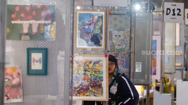 Pengunjung mengamati berbagai karya seni yang ditampilkan dalam Jakarta Illustration and Creative Arts Fair (JICAF) 2026 di Agora Mall, Thamrin, Jakarta, Kamis (1/10/2026). [Suara.com/Alfian Winanto]