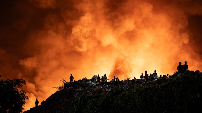 Sejumlah warga menyaksikan api yang membakar tumpukan sampah di Tempat Pembuangan Akhir (TPA) Jatibarang Zona 1, Semarang, Jawa Tengah, Rabu (30/9/2026). [ANTARA FOTO/Aprillio Akbar/YU]
