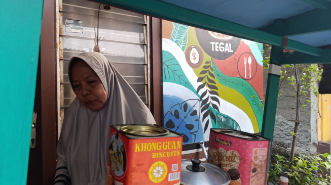 Seorang pedagang ketoprak di RT 11/RW 7, Gandaria Utara, Jakarta Selatan, Ibu Ummi (56), memiliki cara unik untuk mempraktikkan kemampuan bahasa Inggris yang dipelajarinya melalui program latihan gratis di lingkungannya. [Suara.com/Agustin Dwi]