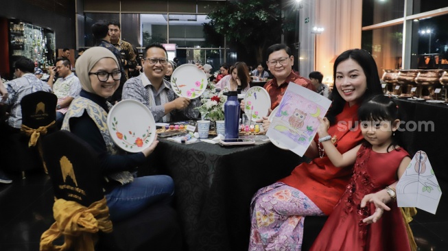 Para tamu menunjukan hasil melukis batik di atas piring dalam acara Batik Reimagined di Manhattan Hotel, Jakarta, Jumat (2/10/2026). [Suara.com/Alfian Winanto]