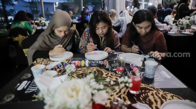 Para tamu melukis batik di atas piring dalam acara Batik Reimagined di Manhattan Hotel, Jakarta, Jumat (2/10/2026). [Suara.com/Alfian Winanto]