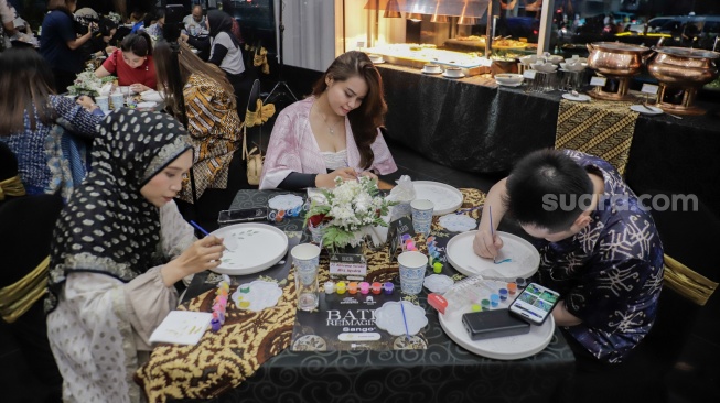 Para tamu melukis batik di atas piring dalam acara Batik Reimagined di Manhattan Hotel, Jakarta, Jumat (2/10/2026). [Suara.com/Alfian Winanto]