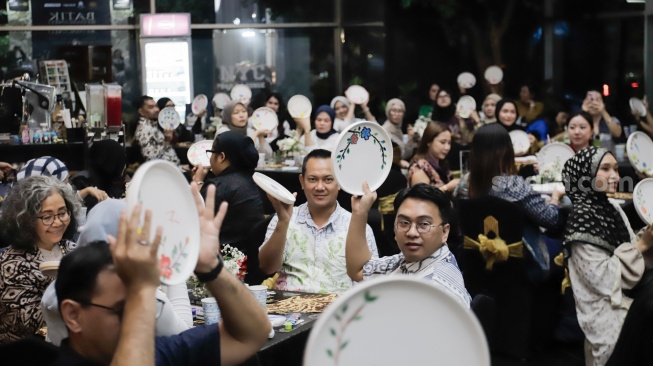 Para tamu menunjukan hasil melukis batik di atas piring dalam acara Batik Reimagined di Manhattan Hotel, Jakarta, Jumat (2/10/2026). [Suara.com/Alfian Winanto]