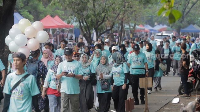 Para peserta mengikuti acara Jalan Sehat dalam rangka perayaan HUT ke-45 Paguyuban Warga Kabupaten Bantul (Warkaban) di Kawasan Stadion Patriot Chandrabhaga,  Bekasi, Jawa Barat pada Minggu, (4/10/2026). [Suara.com/Alfian Winanto]