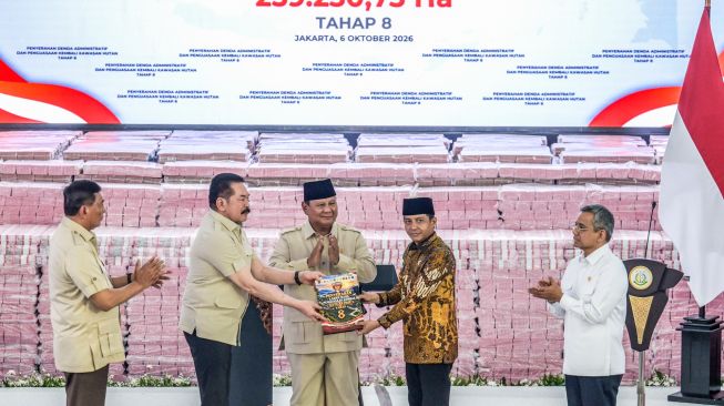 Presiden Prabowo Subianto (tengah) menyaksikan Jaksa Agung ST Burhanuddin (kedua kiri) menyerahkan secara simbolis tanah yang dikuasi kembali oleh negara kepada Menteri Kehutanan Raja Juli Antoni (kedua kanan) didampingi Menteri Pertahanan Sjafrie Sjamsoeddin (kiri) dan Menteri Keuangan Suahasil Nazara (kanan) saat kegiatan penyerahan denda administratif dan lahan kawasan hutan di Kejaksaan Agung, Jakarta, Selasa (6/10/2026). [ANTARA FOTO/Galih Pradipta/agr]