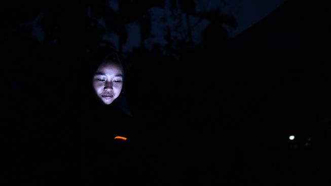 Seorang warga menyalakan lampu senter di rumahnya yang belum mendapatkan layanan listrik di Dusun Suka Jaya, Desa Lagan Ulu, Tanjung Jabung Timur, Jambi, Rabu (7/10/2026). [ANTARA FOTO/Wahdi Septiawan/wsj]