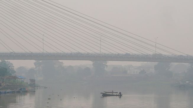 Sejumlah kendaraan melintas di atas jembatan Siak III yang dipenuhi kabut asap di Pekanbaru, Riau, Rabu (7/10/2026). [ANTARA FOTO/Rony Muharrman/YU]