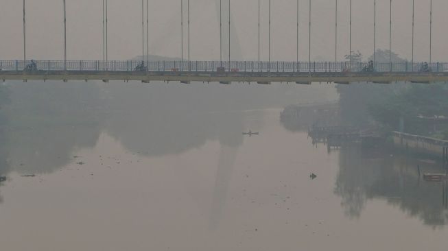 Sejumlah kendaraan melintas di atas jembatan Siak III yang dipenuhi kabut asap di Pekanbaru, Riau, Rabu (7/10/2026). [ANTARA FOTO/Rony Muharrman/YU]