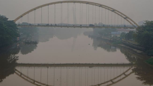 Sejumlah kendaraan melintas di atas jembatan Siak III yang dipenuhi kabut asap di Pekanbaru, Riau, Rabu (7/10/2026). [ANTARA FOTO/Rony Muharrman/YU]