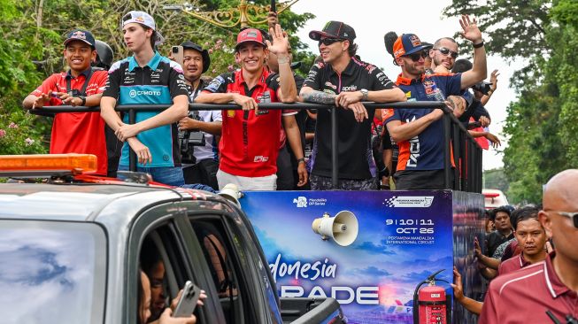 Pembalap Aprilia Racing Marco Bezzecchi (kedua kanan) bersama pembalap Ducati Lenovo Team Marc Marquez (tengah), pembalap Red Bull KTM Factory Racing Brad Binder (kanan), pembalap Honda Team Asia Veda Pratama (kiri), dan pembalap CFMOTO Gaviota Aspar Team Maximo Quiles (kedua kiri) menyapa penggemarnya saat mengikuti MotoGP Riders Parade di Jalan Udayana, Mataram, NTB, Rabu (7/10/2026). [ANTARA FOTO/Ahmad Subaidi/tom]
