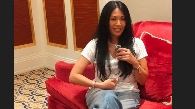 Anggun mencontohkan cara pengambilan napas saat menyanyi kepada crew Suara.com. (Suara.com/CNR ukirsari)