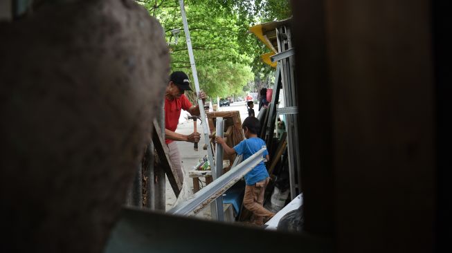 Pedagang membongkar sendiri lapak dagangannya untuk direlokasi di kawasan Setu Babakan, Jakarta, Kamis (8/10/2026). [ANTARA FOTO/Indrianto Eko Suwarso/YU]