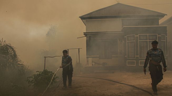 Petugas menarik selang saat memadamkan kebakaran lahan yang mendekati kawasan permukiman warga di Kecamatan Jekan Raya, Palangka Raya, Kalimantan Tengah, Jumat (9/10/2026). [ANTARA FOTO/Auliya Rahman/wsj]