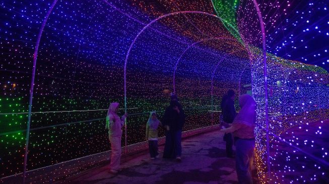 Pengunjung melihat festival lampu Lumiland atau wisata cahaya di Taman Wiradadaha, Kota Tasikmalaya, Jawa Barat, Jumat (9/10/2026). [ANTARA FOTO/Adeng Bustomi/nym]