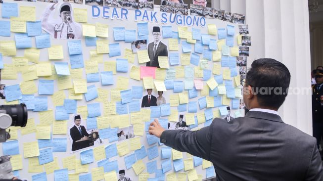 Pejabat lama Menteri Luar Negeri Sugiono melihat ucapan perpisahan para pegawai Kementerian Luar Negeri dalam acara pisah sambut pejabat baru dan lama di Gedung Pancasila, Kementerian Luar Negeri, Jakarta, Senin (12/10/2026). [Suara.com/Alfian Winanto]
