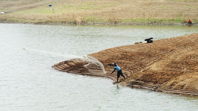 Nelayan lokal menebar jaring di tepi Waduk Wonorejo, Tulungagung, Jawa Timur, Senin (12/10/2026). [ANTARA FOTO/Destyan Sujarwoko/nz]
