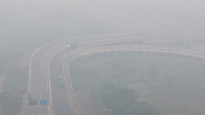 Sejumlah kendaraan melintas di simpang susun Jalan Tol Trans Sumatera (JTTS) ruas Palembang-Lampung yang tertutup kabut asap di Desa Ibul Besar III, Pemulutan, Ogan Ilir (OI), Sumatera Selatan, Selasa (13/10/2026). [ANTARA FOTO/Nova Wahyudi/tom]