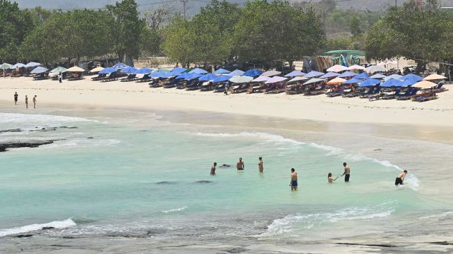 Sejumlah wisatawan berendam di Pantai Tanjung Aan, Kawasan Ekonomi Khusus (KEK) Mandalika, Lombok Tengah, NTB, Selasa (13/10/2026). [ANTARA FOTO/Fikri Yusuf/tom]
