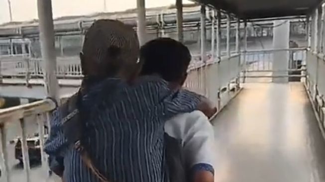 Viral, Petugas Transjakarta Gendong Lansia yang Kesulitan Berjalan di JPO Cempaka Mas