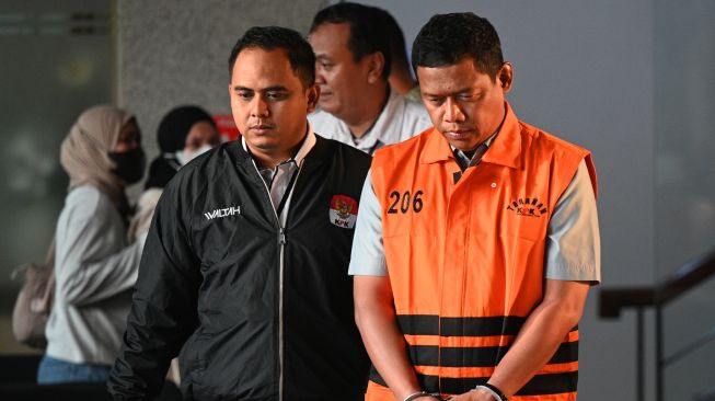 Pihak swasta Bima Setiawan (kanan), adik Kepala BNPB Letjen TNI Suharyanto, berjalan mengenakan rompi tahanan seusai menjalani pemeriksaan di Gedung Merah Putih KPK, Jakarta, Rabu (14/10/2026). [ANTARA FOTO/Fauzan/kye]