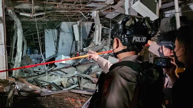 Personel Brimob mengamati lokasi ledakan di Pasar Cimanggis, Tangerang Selatan, Banten, Rabu (14/10/2026). [ANTARA FOTO/Muhammad Iqbal/kye]