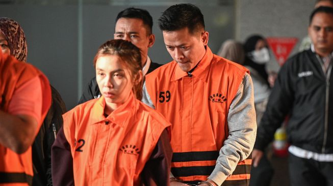 Pihak swasta Gery Prasetiawan (kanan) dan Syifa Nrika Ghifarian (kiri) berjalan mengenakan rompi tahanan seusai menjalani pemeriksaan di Gedung Merah Putih KPK, Jakarta, Rabu (14/10/2026). [ANTARA FOTO/Fauzan/kye]