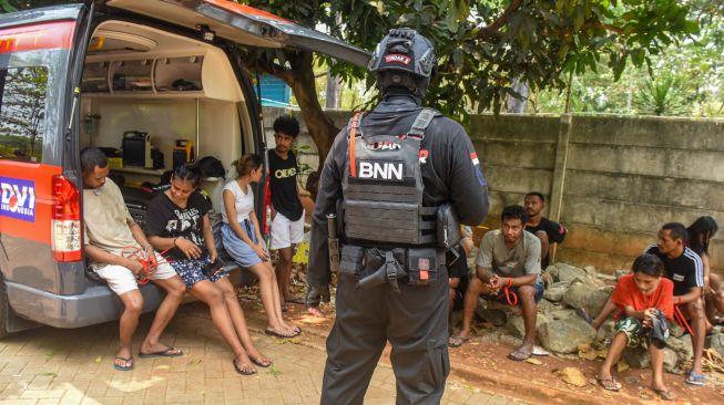 Tim gabungan Direktorat Tindak Pidana Narkoba Bareskrim Polri, Badan Narkotika Nasional (BNN), dan Polda Metro Jaya mengamankan terduga pelaku tindak pidana peredaran narkoba di Kompleks Permata (Kampung Ambon), Kedaung Kaliangke, Cengkareng, Jakarta Barat, Kamis (15/10/2026). [ANTARA FOTO/Muhammad Adimaja/YU]