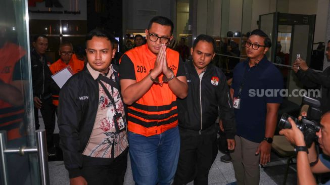 Bupati Klaten Hamenang Wajar Ismoyo (tengah) berjalan menggunakan rompi tahanan usai menjalani pemeriksaan di Gedung Merah Putih KPK, Jakarta, Jumat (16/10/2026). [Suara.com/Alfian Winanto]