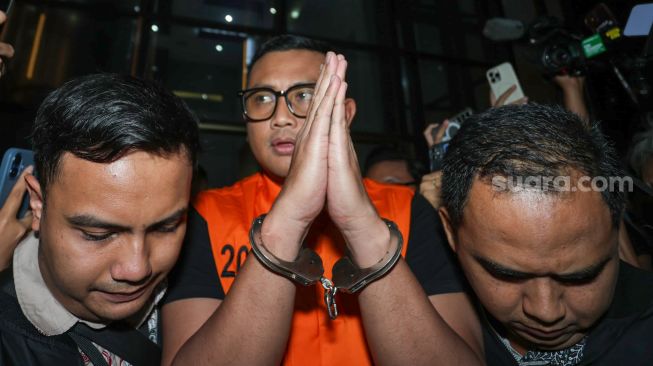 Bupati Klaten Hamenang Wajar Ismoyo berjalan menggunakan rompi tahanan usai menjalani pemeriksaan di Gedung Merah Putih KPK, Jakarta, Jumat (16/10/2026). [Suara.com/Alfian Winanto]
