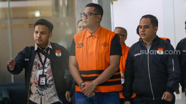 Bupati Klaten Hamenang Wajar Ismoyo berjalan menggunakan rompi tahanan usai menjalani pemeriksaan di Gedung Merah Putih KPK, Jakarta, Jumat (16/10/2026). [Suara.com/Alfian Winanto]
