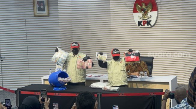 Komisi Pemberantasan Korupsi (KPK) menunjukkan tong biru berisi uang senilai Rp934 juta yang diamankan dari hasil OTT Bupati Klaten, Hamenang Wajar Ismoyo (HWI) di Gedung Merah Putih, Jakarta Selatan, Jumat (16/10/2026). [Suara.com/Dea]