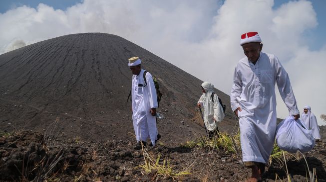 Perangkat Bobato Akhirat Kesultanan Ternate (depan) bersama warga menuju zere (makam keramat) di puncak Gunung Gamalama dalam ritual adat Fere Kie di Ternate, Maluku Utara, Minggu (18/10/2026). [ANTARA FOTO/Andri Saputra/kye]