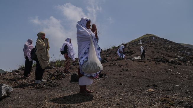 Warga berdoa di hadapan Gunung Gamalama sebelum berziarah ke zere (makam keramat) di puncak gunung tersebut dalam ritual adat Fere Kie di Ternate, Maluku Utara, Minggu (18/10/2026). [ANTARA FOTO/Andri Saputra/kye]