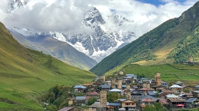 Pemandangan Desa Ushguli dengan latar Pegunungan Kaukasus dan Gunung Shkhara di wilayah Svaneti, Georgia, Minggu (27/9/2026). [Suara.com/Rizka Chaerani]

