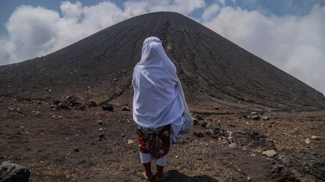 Warga berdoa di hadapan Gunung Gamalama sebelum berziarah ke zere (makam keramat) di puncak gunung tersebut dalam ritual adat Fere Kie di Ternate, Maluku Utara, Minggu (18/10/2026). [ANTARA FOTO/Andri Saputra/kye]