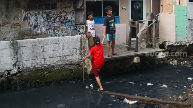 Warga beraktivitas di bantaran Anak Kali Krukut, kawasan Kebon Melati, Tanah Abang, Jakarta, Senin (19/10/2026). [Suara.com/Alfian Winanto]