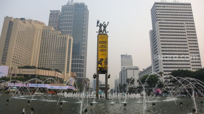 Sejumlah aktifis Greenpeace membentangkan spanduk yang bertema krisis iklim di Bundaran HI, Jakarta, Selasa (20/10/2026). [Suara.com/Alfian Winanto]
