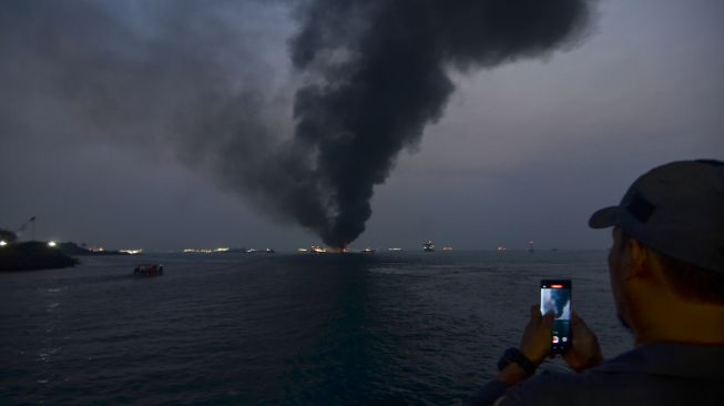 Warga memotret Kapal Motor Penumpang (KMP) Batumandi yang terbakar di perairan Pelabuhan Merak, Kota Cilegon, Banten, Selasa (20/10/2026Kapal Motor Penumpang (KMP) Batumandi yang terbakar di perairan Pelabuhan Merak, Kota Cilegon, Banten, Selasa (20/10/2026). [ANTARA FOTO/Rikardo/pma/nym]