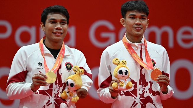 Pebulu tangkis ganda putra Indonesia Muh Al Imran (kanan) dan Suryo Nugroho (kiri) menunjukkan medali emasnya usai mengalahkan pasangan Korea Selatan Shin Kyung Hwan dan Cho Nadan pada final ganda putra SL3-SU5 Asian Para Games 2026 di Municipal Gymnasium, Ichinomiya, Nagoya, Jepang, Jumat (23/10/2026). [ANTARA FOTO/M Risyal Hidayat/nz]