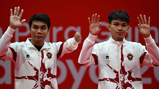 Pebulu tangkis ganda putra Indonesia Muh Al Imran (kanan) dan Suryo Nugroho (kiri) melambaikan tangan saat upacara medali usai mengalahkan pasangan Korea Selatan Shin Kyung Hwan dan Cho Nadan pada final ganda putra SL3-SU5 Asian Para Games 2026 di Municipal Gymnasium, Ichinomiya, Nagoya, Jepang, Jumat (23/10/2026). [ANTARA FOTO/M Risyal Hidayat/nz]
