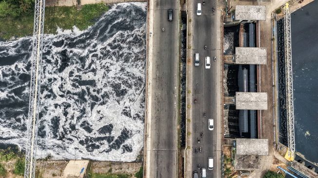 Foto udara aliran Kali Bekasi yang berbusa dan berwarna hitam, diduga akibat pencemaran limbah, di kawasan Margahayu, Kota Bekasi, Jawa Barat, Jumat (23/10/2026). [ANTARA FOTO/Darryl Ramadhan/kye]