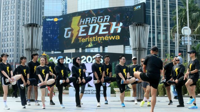 Komunitas lari tiket.com, tiket runners, melakukan pemanasan sebelum memulai lari pagi bersama di kawasan Pacific Place, Jakarta.