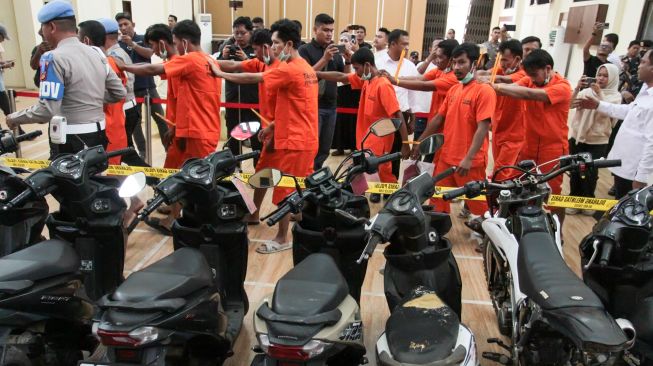 Polisi menghadirkan barang bukti motor bersama tersangka pencurian kendaraan bermotor saat pengungkapan curanmor di Polres Lhokseumawe, Aceh, Senin (26/10/2026). [ANTARA FOTO/Rahmad/agr]