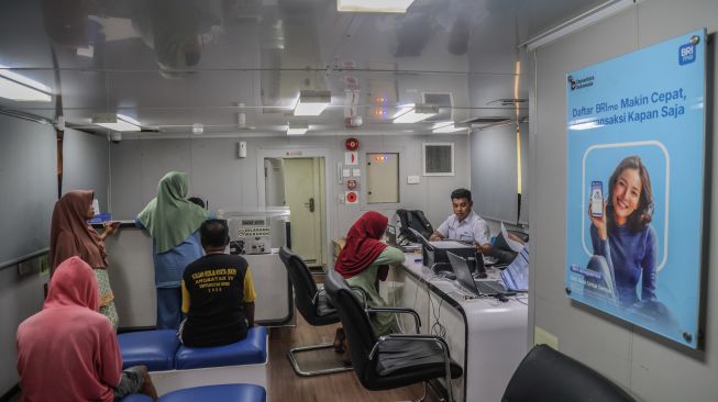 Warga menunggu antrean layanan perbankan di Kapal Teras Bahtera Seva II milik Bank Rakyat Indonesia (BRI) di Desa Bajo Sangkuang, Kecamatan Botang lomang, Kabupaten Halmahera Selatan, Maluku Utara, Senin (26/10/2026). [ANTARA FOTO/Andri Saputra/agr]