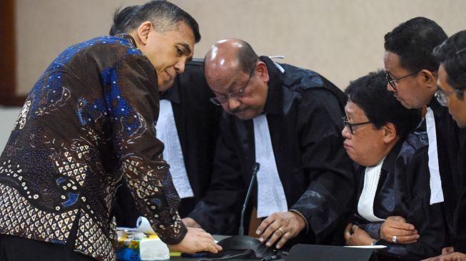 Terdakwa kasus dugaan pemerasan dan gratifikasi pengurusan izin tinggal WNA di lingkungan Ditjen Imigrasi, Silmy Karim (kiri) berbincang dengan kuasa hukumnya saat mengikuti sidang pembacaan surat dakwaan di Pengadilan Tipikor, Jakarta, Kamis (29/10/2026). [ANTARA FOTO/Indrianto Eko Suwarso/nz]